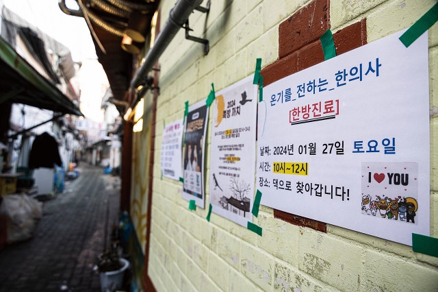 서울 종로구 창신동 쪽방촌 골목에 ‘온기를 전하는 한의사들’의 의료봉사 일정 공지문이 붙어 있다. 사진 C영상미디어