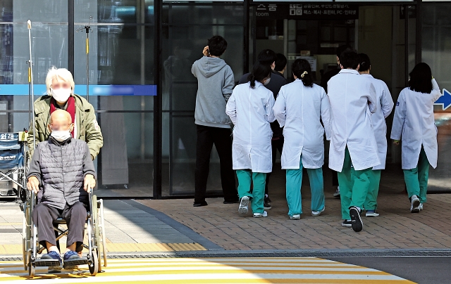 의사 집단행동이 계속되고 있는 3월 4일 서울 시내의 한 대학병원에서 환자 옆으로 의료진이 이동하고 있다. 사진 뉴시스
