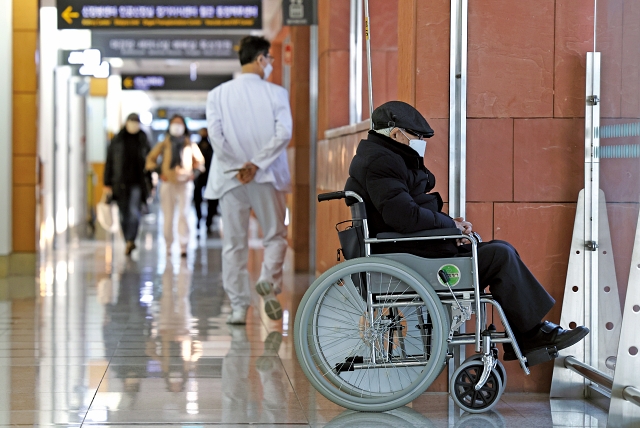 의사 집단행동이 계속되고 있는 가운데 3월 13일 서울의 한 대학병원에서 휠체어에 앉은 환자가 생각에 잠겨 있다. 사진 뉴시스