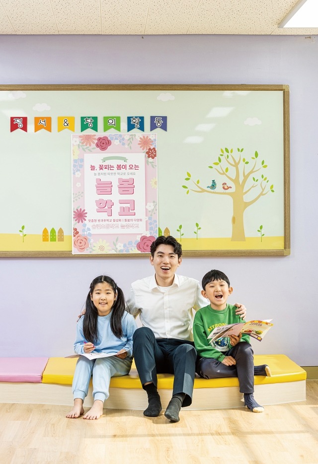 경기 화성시 송린초등학교에서 늘봄학교를 담당하고 있는 박성환 교사가 3학년 이효주 (사진 왼쪽), 강민준 학생과 함께 웃고 있다. 사진 C영상미디어