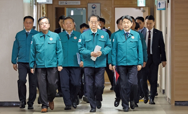 한덕수 국무총리와 이주호 부총리 겸 교육부 장관(오른쪽) 등이 3월 20일 의료개혁 관련 대국민 담화와 의과대학 학생 정원 대학별 배정 결과·발표를 위해 합동브리핑실로 향하고 있다. 사진 뉴시스