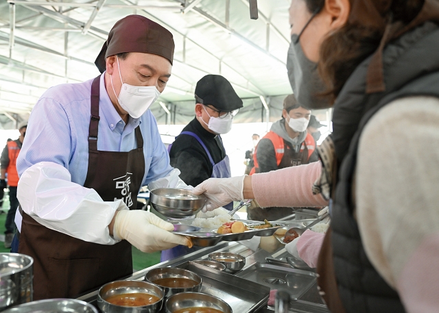 윤석열 대통령이 3월 27일 서울 중구 명동성당 내 무료 급식소인 명동밥집을 찾아 배식 봉사활동을 하고 있다. 사진 대통령실