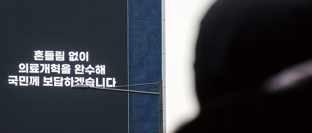 전공의들의 의료현장 이탈이 장기화되는 가운데 3월 12일 서울시내 한 건물 외벽 전광판에 정부의 &lsquo;의료개혁 완수&rsquo; 광고가 나오고 있다. 사진 뉴시스