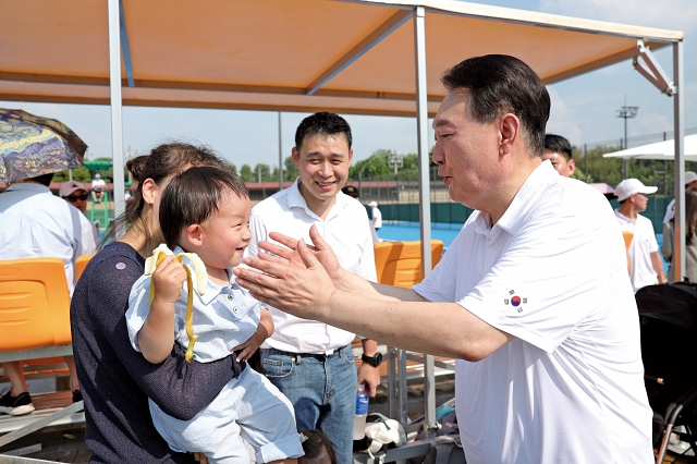 윤석열 대통령이 2023년 8월 26일 서울 용산어린이정원 분수정원에서 열린 다둥이가족 초청행사에서 한 아이와 인사하고 있다. 사진 대통령실