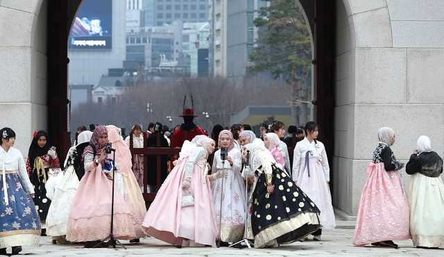 한복을 입은 외국인 관광객들이 경복궁 앞에서 촬영을 하며 즐거워하고 있다. 사진 뉴시스