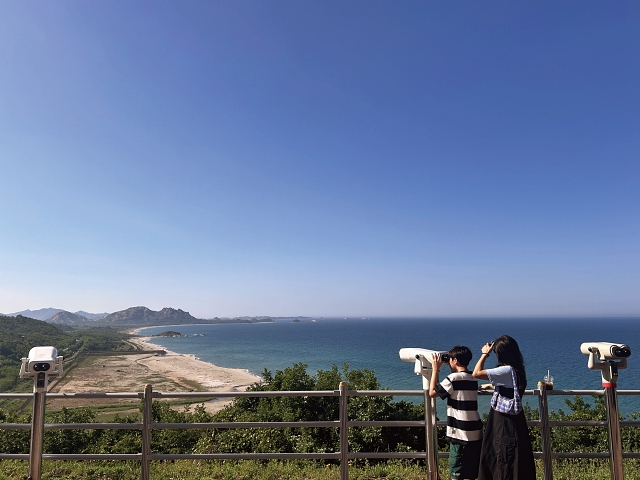 강원 고성군 고성통일전망타워 전망대를 찾은 관람객이 망원경으로 DMZ 너머 금강산과 해금강을 바라보고 있다