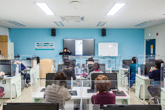 ‘디지털 문해 스마트폰 기초’ 수업에 참석한 수강생들이 강사의 안내를 따라 스마트폰을 작동시키고 있다. 사진 C영상미디어