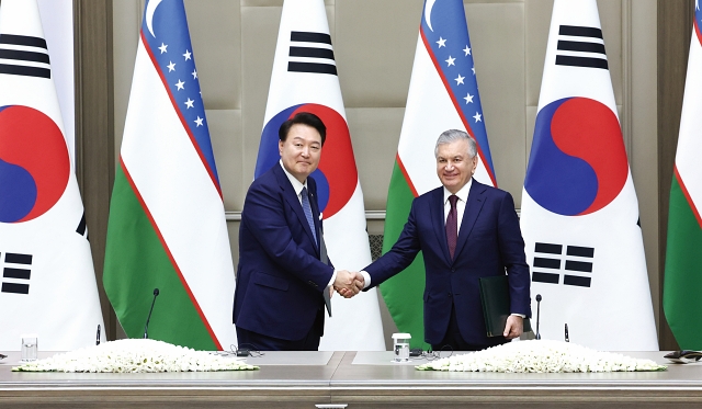 우즈베키스탄을 국빈 방문한 윤석열 대통령이 6월 14일 샤브카트 미르지요예프 우즈베키스탄 대통령과 공동성명에 서명한 후 악수하고 있다. 사진 뉴시스