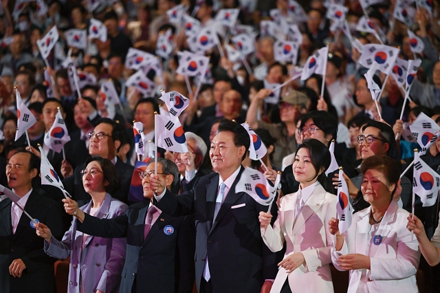 윤석열 대통령과 부인 김건희 여사가 8월 15일 서울 종로구 세종문화회관에서 열린 ‘제79주년 광복절 경축식’에서 태극기를 흔들고 있다. 사진 대통령실