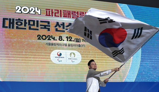 8월 12일 서울 송파구 올림픽파크텔에서 열린 2024 파리 패럴림픽 결단식에서 배동현 선수단장이 태극기를 흔들고 있다. 사진 문화체육관광부