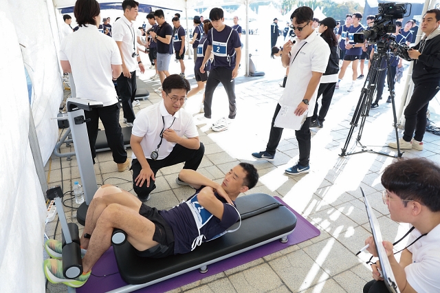 교차 윗몸일으키기 측정이 한창인 참가자.