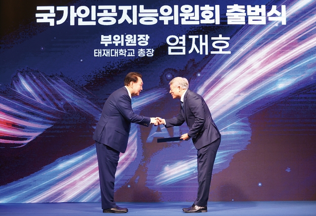 윤석열 대통령이 9월 26일 열린 국가인공지능(AI)위원회 출범식 및 1차 회의에서 염재호 부위원장에게 위촉장을 수여하고 있다. 사진 뉴시스