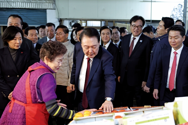 윤석열 대통령이 12월 2일 충남 공주시 아트센터 고마에서 &lsquo;다시 뛰는 소상공인&middot;자영업자, 활력 넘치는 골목상권&rsquo;을 주제로 열린 국민과 함께하는 민생토론회를 마친 뒤 찾은 공주산성시장에서 한 상인과 이야기를 나누고 있다. 사진 대통령실