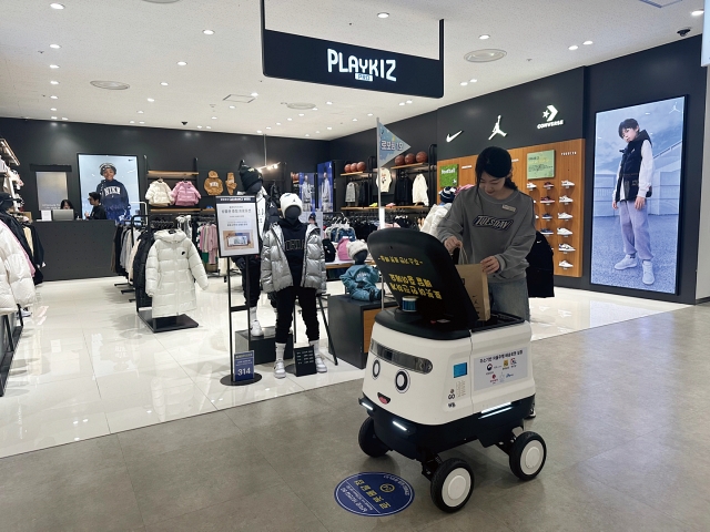 마트에서 구입한 물품을 로봇이 알아서 주차장까지 배달해주는 시대가 열린다. 사진은 점원이 고객에게 보낼 물품을 로봇에 적재하고 있는 모습. 사진 행정안전부