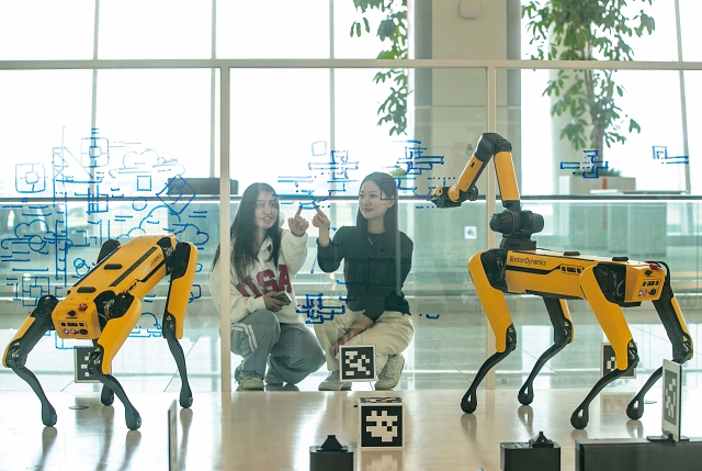 2024년 12월 16일 인천국제공항 제2여객터미널에서 시민들이 사족보행 로봇이 생성형 인공지능(AI)을 통해 그리는 서울 도심의 그림을 바라보고 있다. 사진 뉴시스