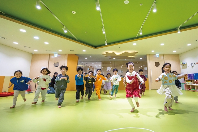 HD현대 사내 어린이집 &lsquo;드림보트&rsquo; 내 마련된 실내 운동장에서 아이들이 교사에게 스티커를 붙이기 위해 힘차게 달려가고 있다. 사진 C영상미디어