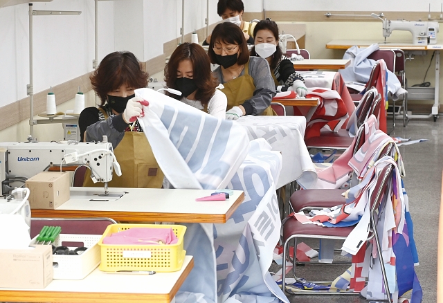 2022년 6월 경기 수원시가족여성회관에서 여성들이 폐현수막을 활용해 낙엽 수거용 자루를 만들고 있다. 사진 뉴시스