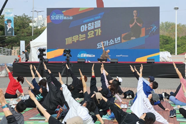 4월 20일 서울 송파구 올림픽공원 만남의광장에서 열린 ‘2025 스포츠주간 오운완 액티브 페스타’에서 참가자들이 인기 유튜버 요가소년을 따라 요가 자세를 취하고 있다. 사진 문화체육관광부