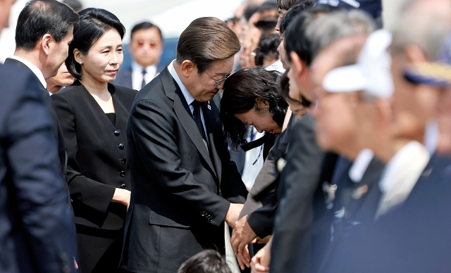 이재명 대통령이 6월 6일 서울 동작구 국립서울현충원에서 열린 제70회 현충일 추념식에 입장하며 한 유족을 위로하고 있다. 사진 뉴시스