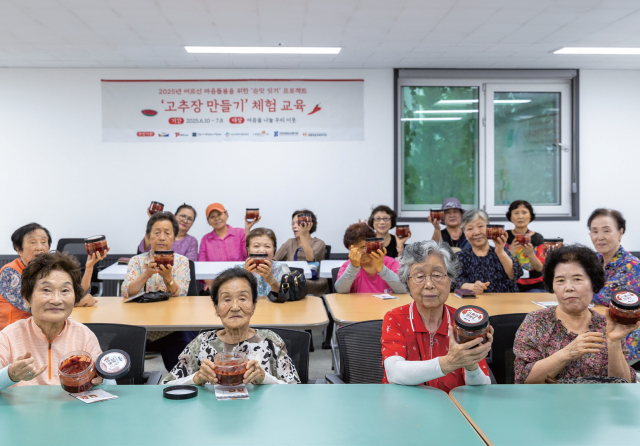 궂은 날씨에도 교육장을 찾은 참가자들이 고추장을 완성한 뒤 함께 웃고 있다.