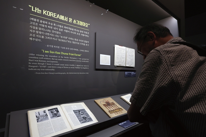 ‘두 발로 세계를 제패하다’ 특별전을 찾은 한 관람객이 손기정 선수가 쓴 엽서를 살펴보고 있다. 사진 뉴시스