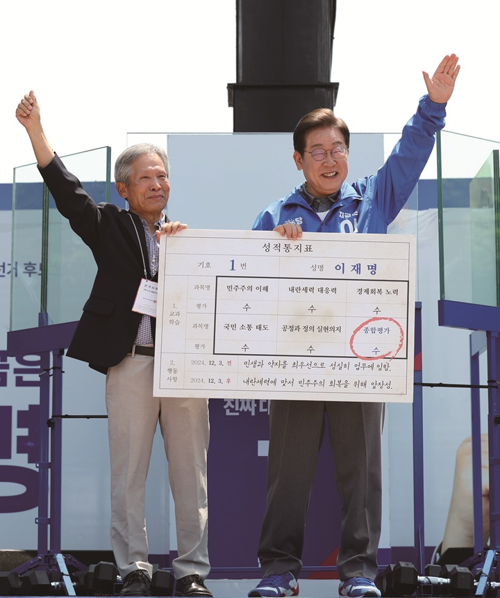 이재명 대통령이 6월 1일 경북 안동시 웅부공원에서 열린 유세에서 초등학교 은사인 박병기 씨로부터 '대선 후보 모의 성적통지표'를 받고 기념촬영을 하고 있다. 사진 뉴시스