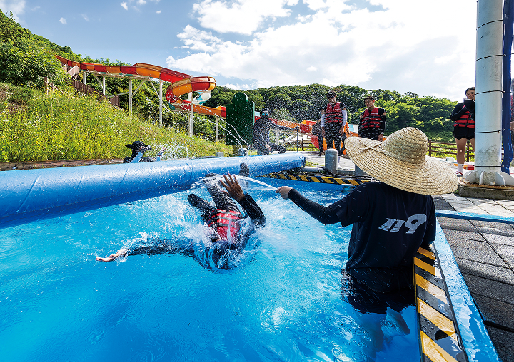 체험객들이 워터 슬라이드 옆에서 통나무 건너기 체험을 하고 있다. 사진 C영상미디어