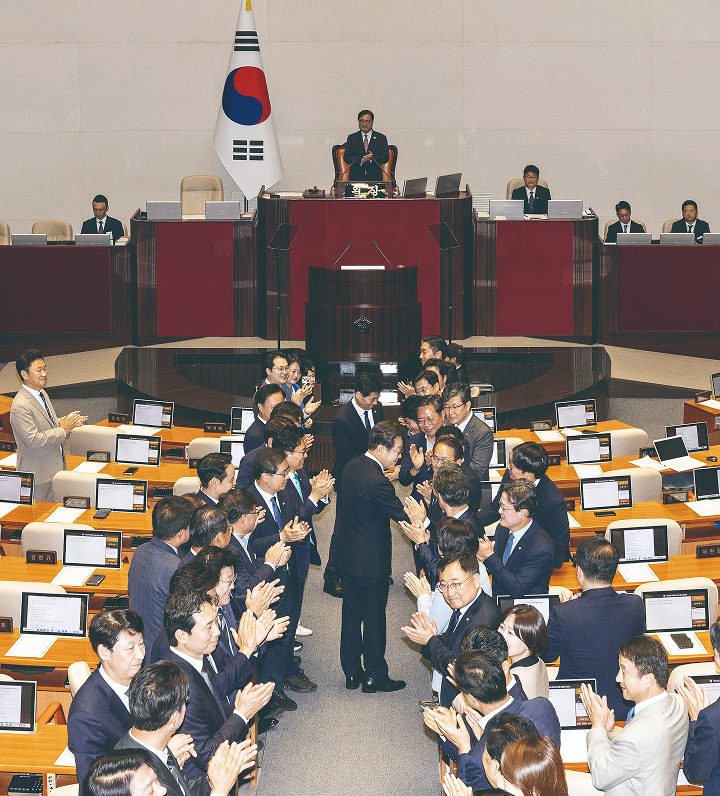 이재명 대통령이 6월 26일 서울 영등포구 국회 본회의장에서 추가경정예산안 시정연설을 하기 전 여야 의원들과 악수를 하고 있다. 사진 뉴시스