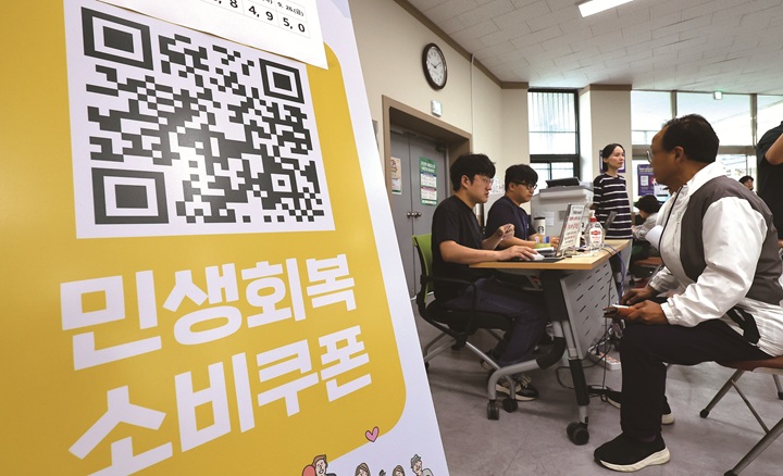 2차 민생회복 소비쿠폰 신청 첫날인 9월 22일 부산 부산진구 가야2동주민센터에서 시민들이 지원금을 받고 있다. 사진 뉴시스