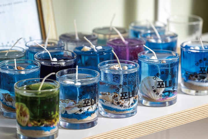 색모래와 조개껍데기로 바다를 닮은 양초를 만드는 체험 프로그램은 가족 방문객에게 인기다.