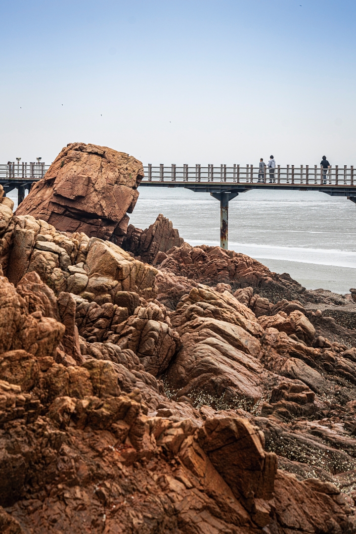 바다 위로 이어진 나무 데크를 걸으며 기암괴석과 바닷바람을 즐기는 탐방객들. 사진 C영상미디어