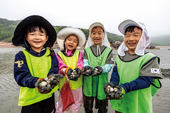 조개캐기 체험에 나선 아이들의 두 손에 갯벌에서 직접 잡은 조개가 한가득이다. 사진 C영상미디어