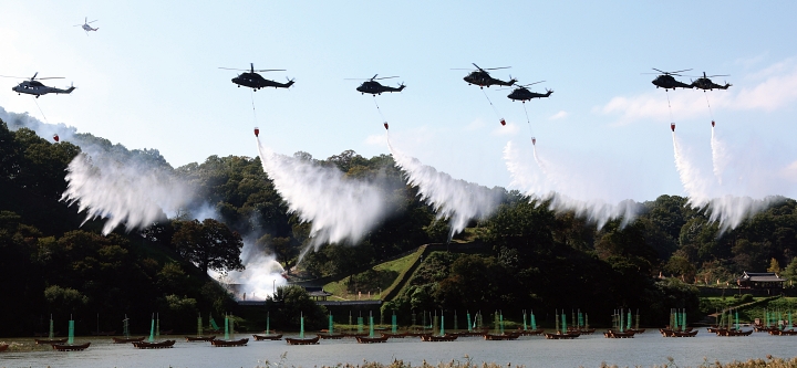 10월 22일 충남 공주시 금강변에서 열린 2025 산불진화 통합훈련에서 산불진화헬기들이 방수하고 있다. 사진 뉴시스