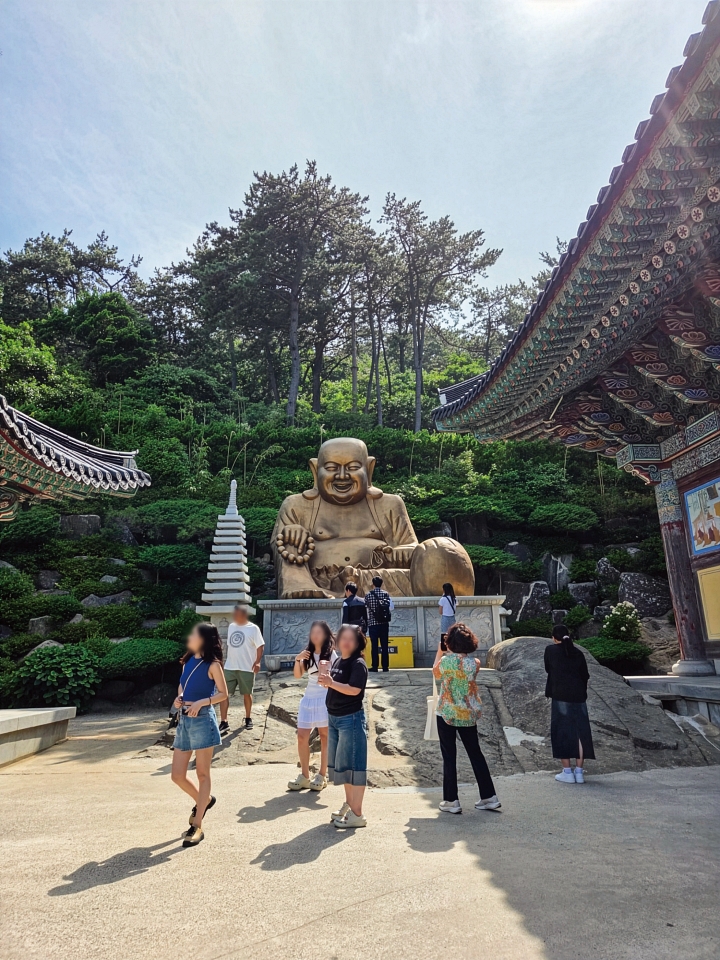 우람한 포대화상 앞에서 방문객들이 발걸음을 멈추고 서 있다. 사진 이근하