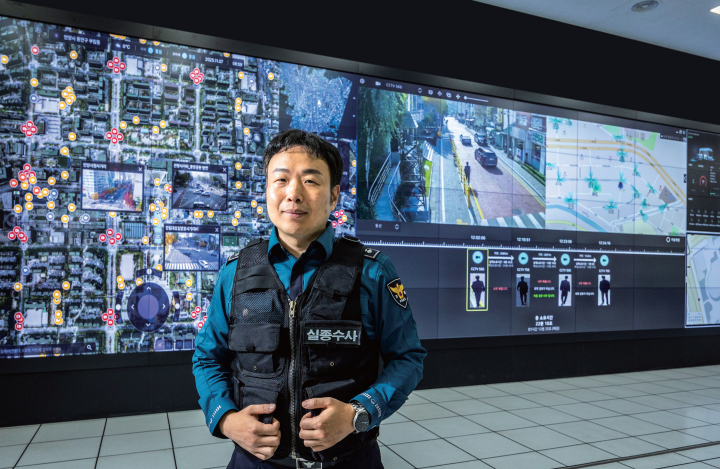 ‘AI 복합 인지 동선 추적(에이드)’ 시스템을 활용해 여러 실종 사건을 해결한 안양동안경찰서 실종전담팀 손현석 경사가 안양시 전역의 폐쇄회로(CC)TV를 확인할 수 있는 안양시 스마트도시통합센터 대형 전광판 앞에 서 있다. 사진 C영상미디어