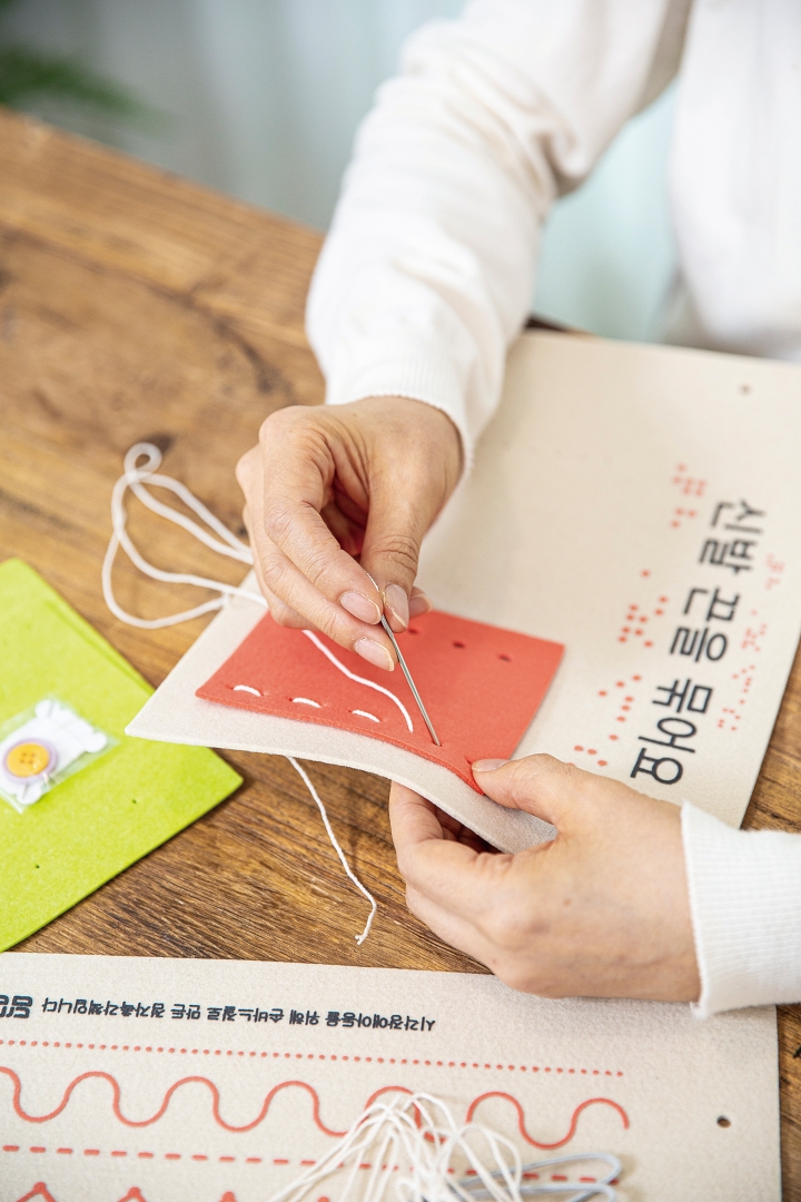 박귀선 대표가 교구재 &lsquo;혼자서도 잘해요&rsquo;에 바느질 시연을 하고 있다. 박 대표는 누구나 쉽게 만들 수 있도록 키트를 구성했다. 사진 C영상미디어