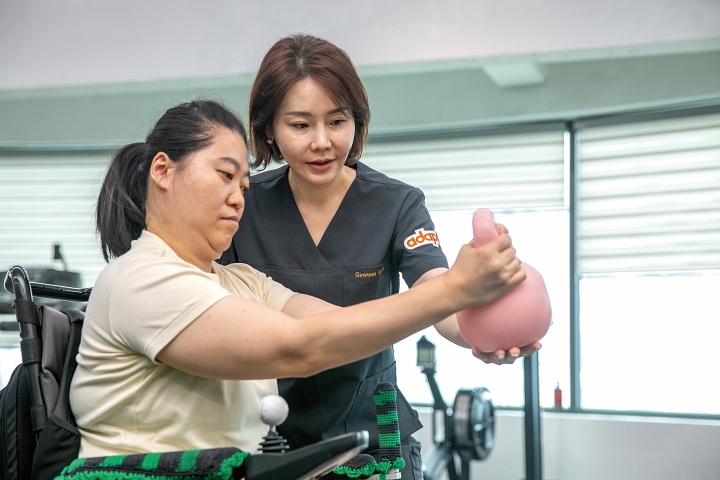 하루하루움직임연구소 정고운 대표가 휠체어를 이용하는 수강생에게 맞춤형 운동법을 지도하고 있다.