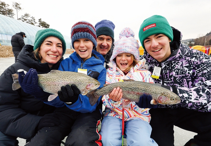 강원 평창군에서 열린 평창송어축제 송어얼음낚시장을 찾은 외국인 관광객들이 맨손 송어 잡기 체험을 즐기고 있다. 사진 평창군