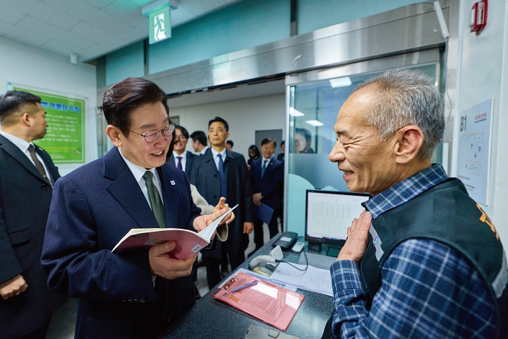 이재명 대통령이 2월 11일 충북 충주시 건강복지타운 그냥드림 현장에서 직원의 일기장을 건네받은 후 대화를 나누고 있다. 사진 청와대