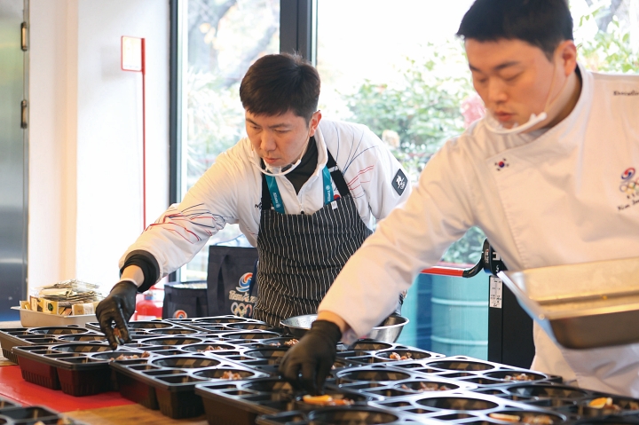 유승민 대한체육회장이 2월 6일 이탈리아 밀라노 급식지원센터에서 도시락 제작에 참여하고 있다. 사진 뉴시스