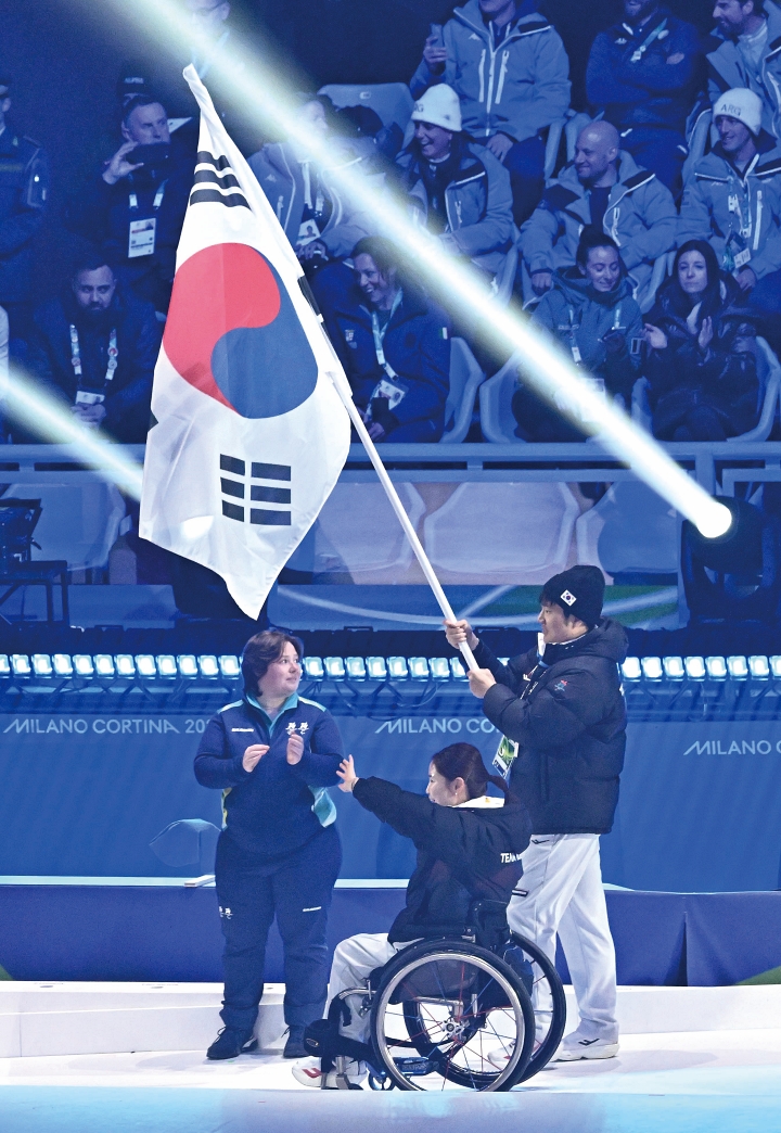 3월 15일(현지시간) 이탈리아 코르티나담페초 컬링 올림픽 스타디움에서 열린 2026 밀라노-코르티나 동계패럴림픽 폐회식에서 휠체어컬링 백혜진과 스노보드 이제혁이 태극기를 들고 입장하고 있다. 사진 뉴시스