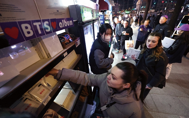 3월 21일 서울 종로구 광화문광장에서 열린 &lsquo;BTS 컴백 라이브: 아리랑(ARIRANG)&rsquo; 공연이 끝난 뒤 한 해외 팬이 인근 편의점에서 앨범을 구매하고 있다. 사진 뉴시스