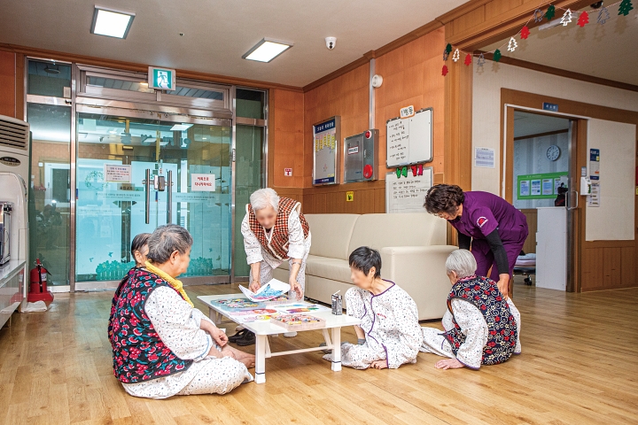 온돌 병동에서 지내는 치매 환자들이 삼삼오오 모여 그림 그리기 활동을 하고 있다. 경도요양병원은 낙상 위험이 큰 환자들을 위해 높이가 낮은 침상을 갖춘 온돌 병동을 운영한다. 사진 C영상미디어