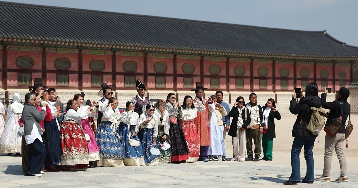 한복 차림의 외국인 관광객들이 서울 종로구 경복궁을 배경으로 기념사진을 촬영하고 있다. 사진 뉴시스