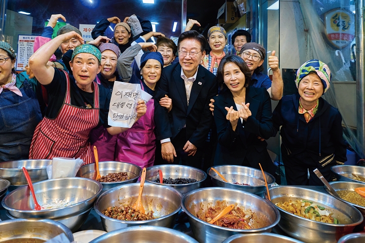 민생 경기를 점검하기 위해 5월 23일 경남 김해시 외동전통시장을 찾은 이재명 대통령과 김혜경 여사가 상인들의 환영을 받고 있다. 사진 청와대