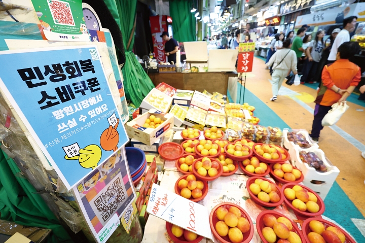 2025년 9월 21일 서울 마포구 망원시장의 한 상점에 민생회복 소비쿠폰 사용 가능 안내문이 게시돼 있다. 사진 뉴시스