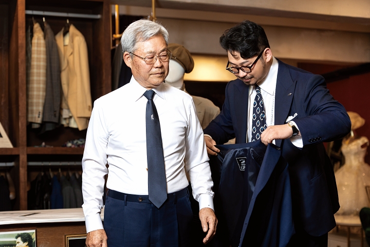 김주현바이각 김주현 대표가 5월 맞춤정장 후원 대상자로 선정된 김송우 베트남전 참전유공자에게 완성된 정장 재킷을 입혀주고 있다.