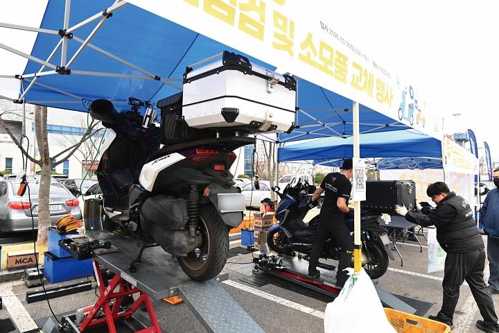 3월 30일 경기 수원시 장안구 수원종합운동장 주차장에 마련된 배달종사자 이륜자동차 안전점검 부스에서 한국오토바이정비협회 정비사들이 무상 안전점검을 하고 있다. 사진 뉴시스