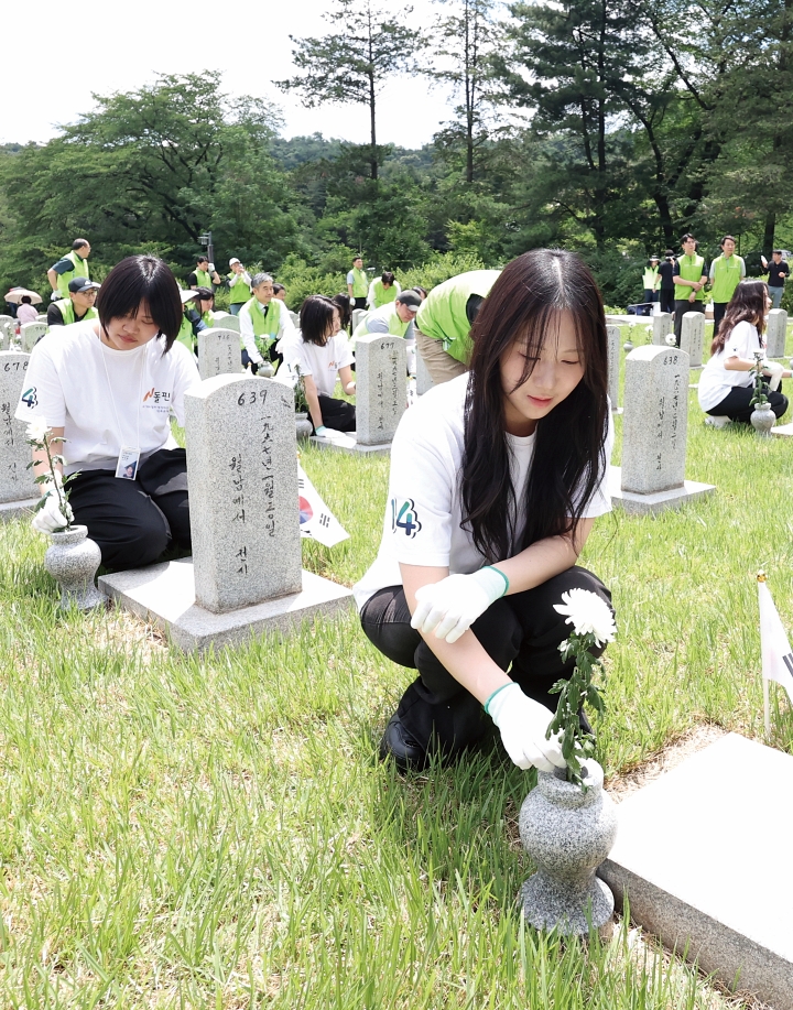 현충일을 하루 앞둔 6월 5일 서울 동작구 국립서울현충원에서 봉사단이 헌화하고 있다. 사진 뉴시스