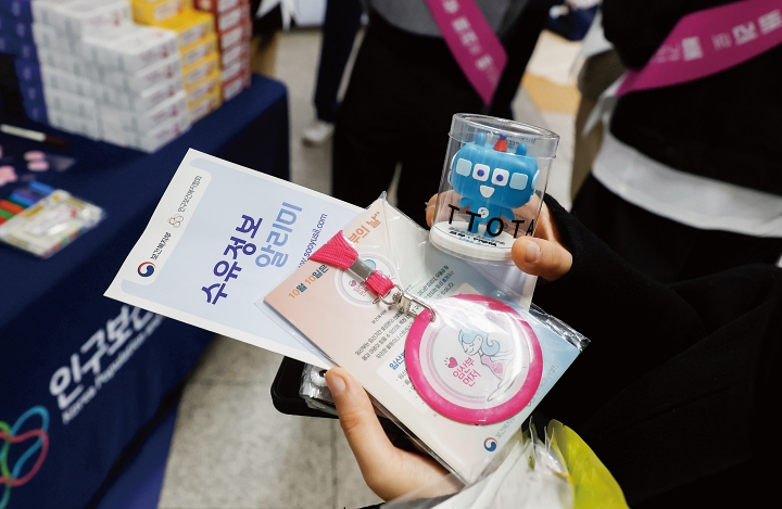 4월 28일 서울 영등포구 여의도역 대합실에서 열린 ‘2026년 임산부 배려 공동 캠페인’에서 한 임산부가 배지와 ‘수유정보 알리미’ 책자를 들고 있다. 사진 뉴시스